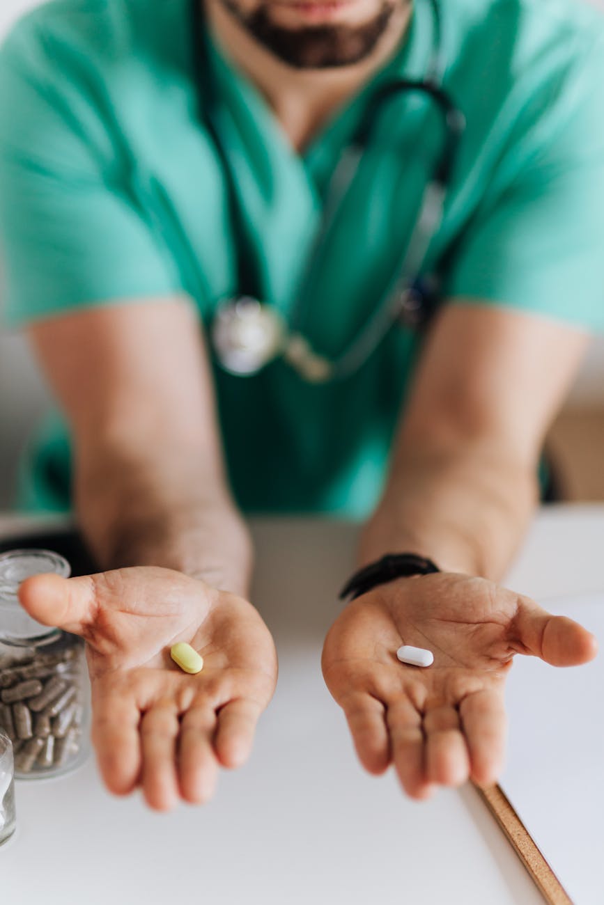 crop doctor showing pills to patient in clinic